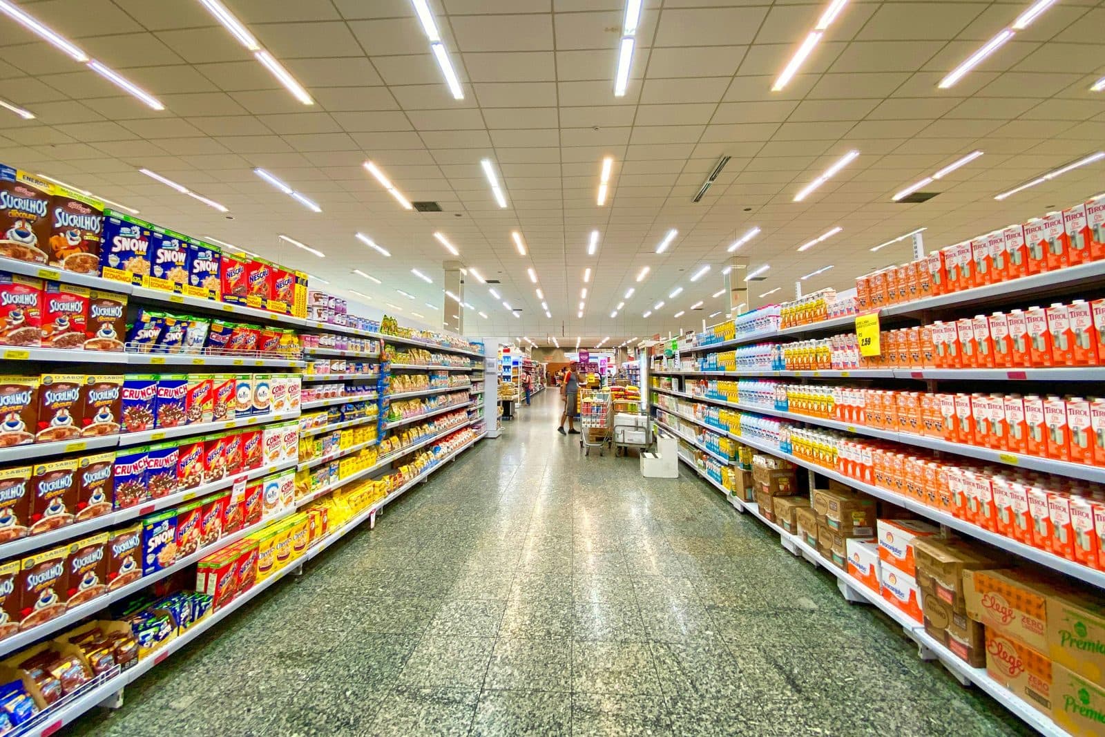 Pasillo de supermercado con góndolas llenas de productos a ambos lados